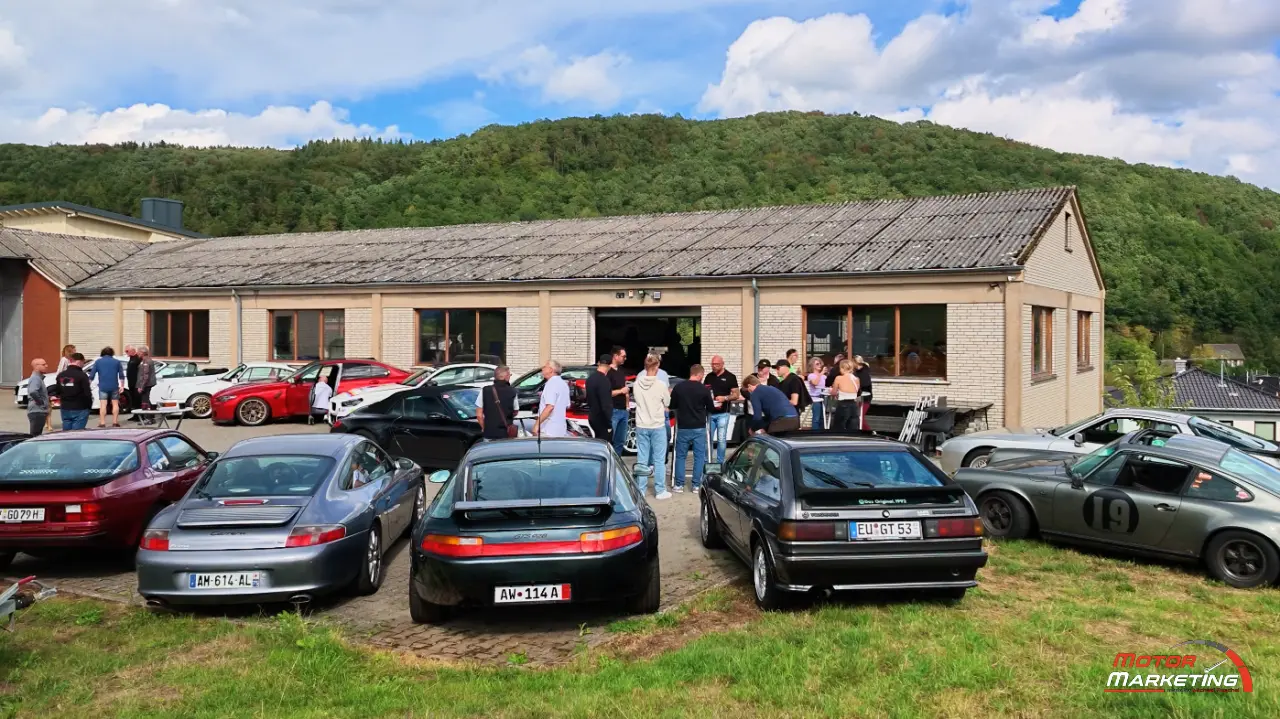 Sportwagen und Besucher beim After Work Meeting auf dem Werkstatthof